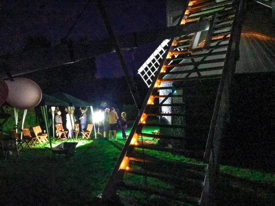 an event at the mill with lots of people, and lights illuminating as it is dark